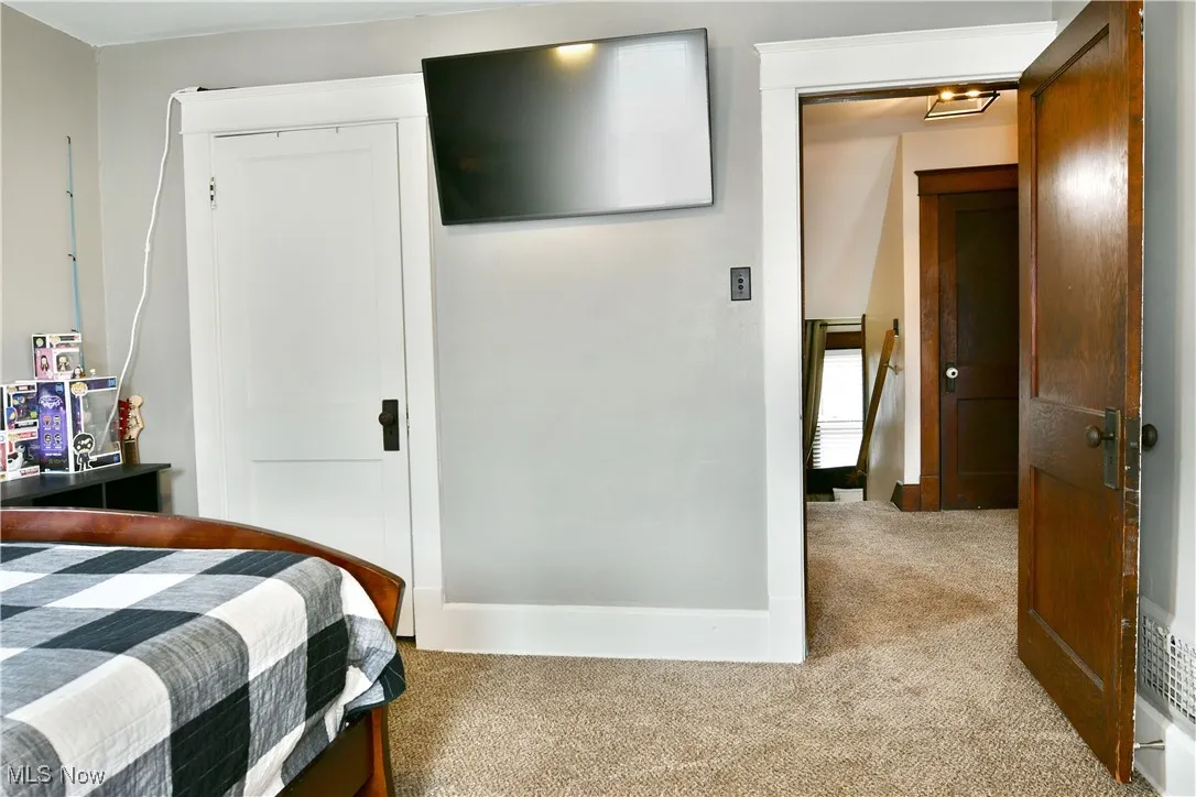Bedroom featuring light carpet and a closet