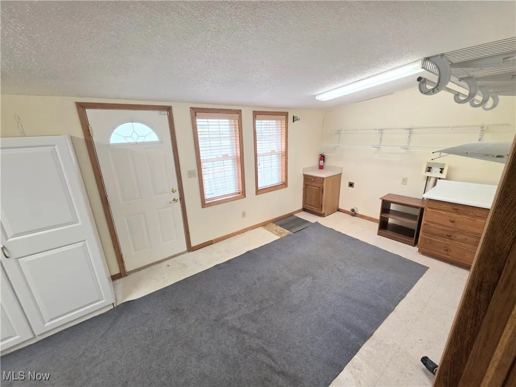 Foyer featuring a textured ceiling and light floors