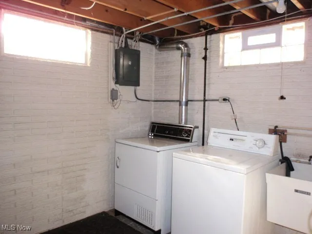 Laundry area featuring electric panel and washer and dryer