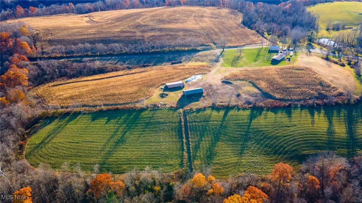 Aerial view of property and surrounding area featuring rural landscape and farmland