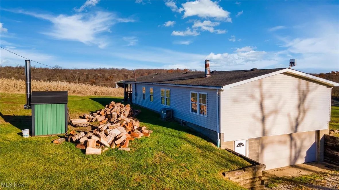 View of property exterior with a lawn and a garage