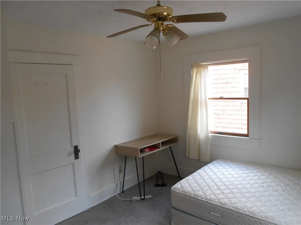 Bedroom with a ceiling fan and carpet