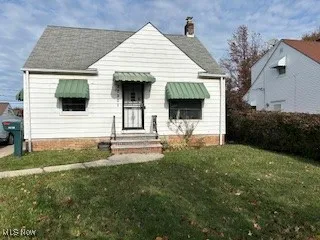 Bungalow-style house with a front lawn, a chimney, and a shingled roof