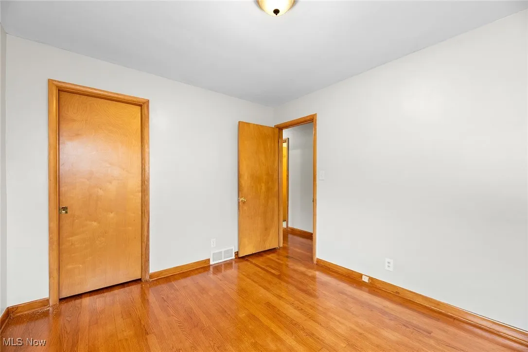 Bedroom with wood finished floors and baseboards
