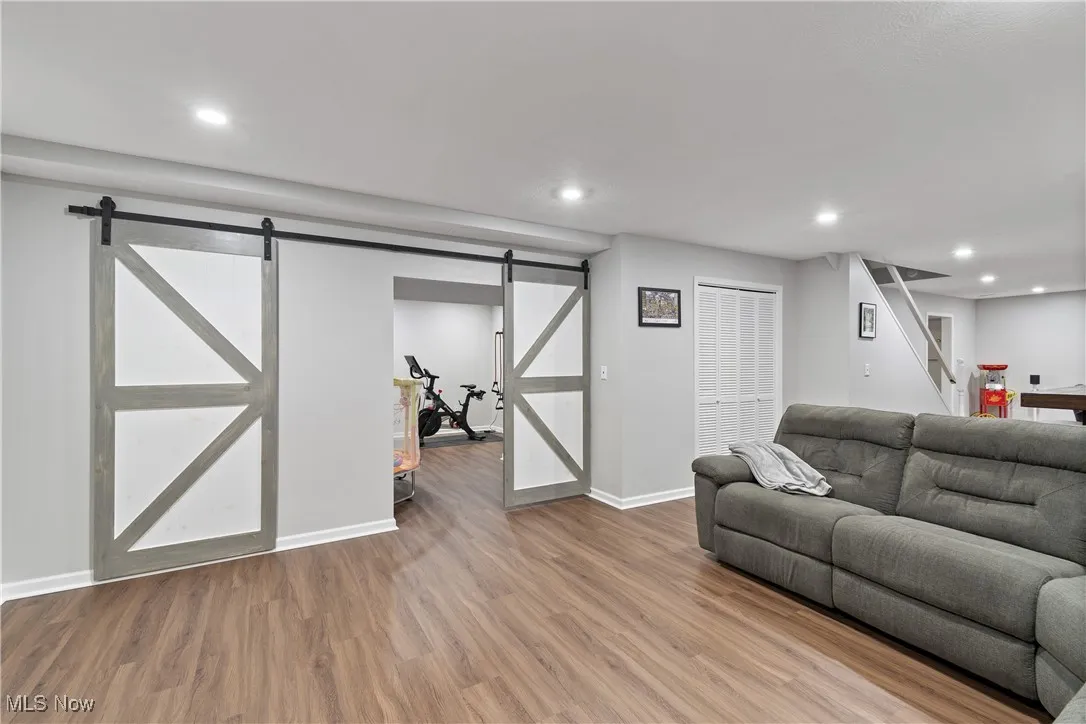Living area with wood finished floors, recessed lighting, and stairs