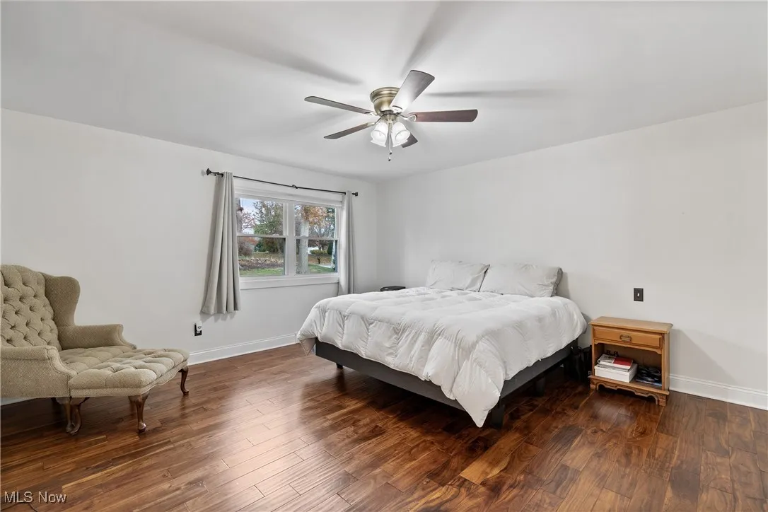 Bedroom with dark wood-style floors and a ceiling fan