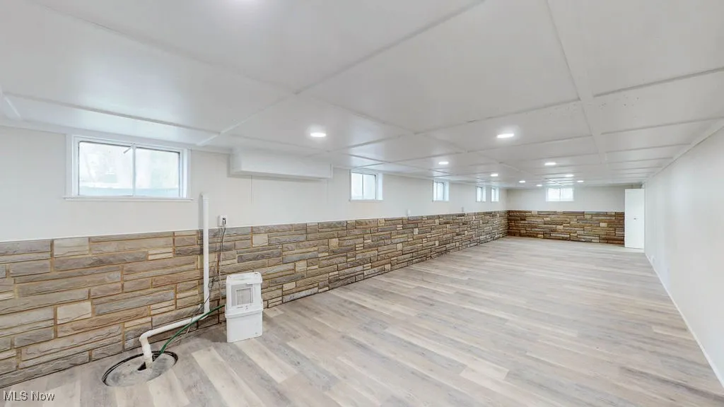 Large recreation room with recessed lighting and luxury vinyl plank flooring.