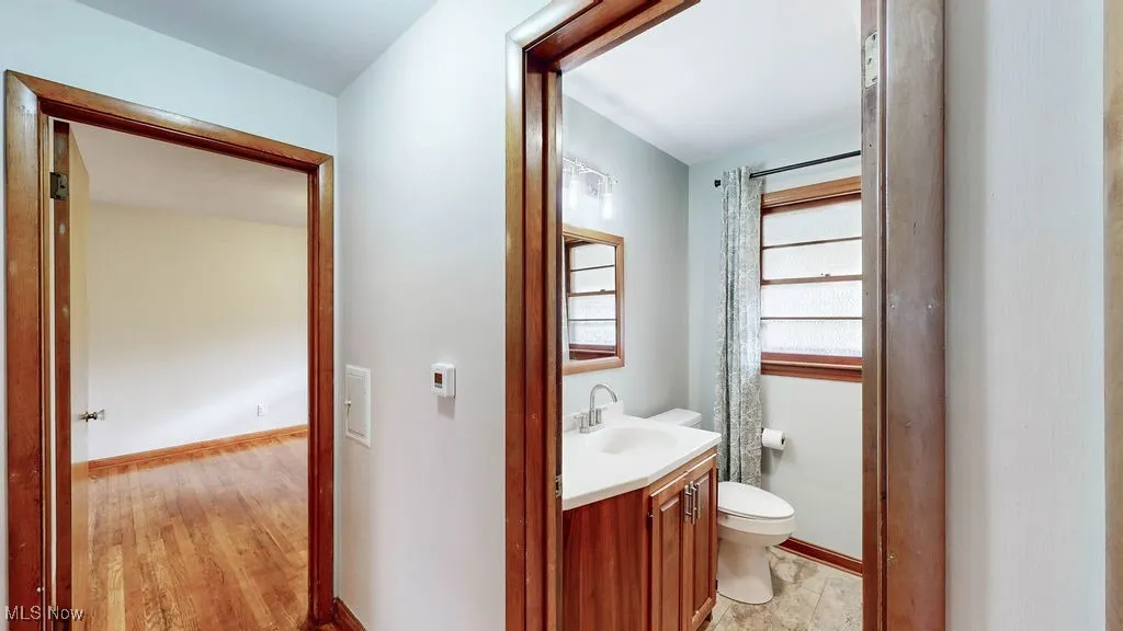 Bathroom with vanity, a shower with curtain, and light wood floors
