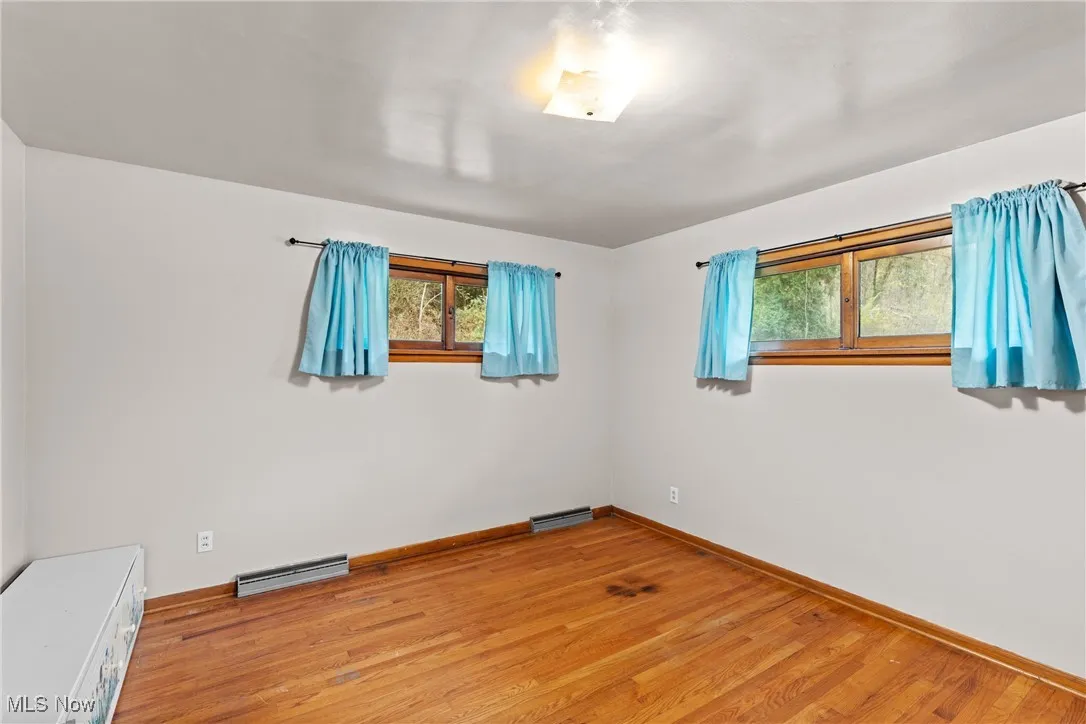 Spare room featuring light wood-style flooring and a baseboard radiator