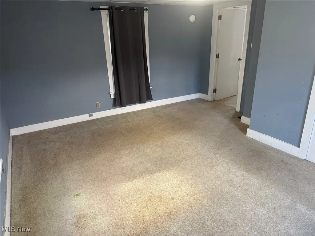 Empty room with baseboards and carpet floors