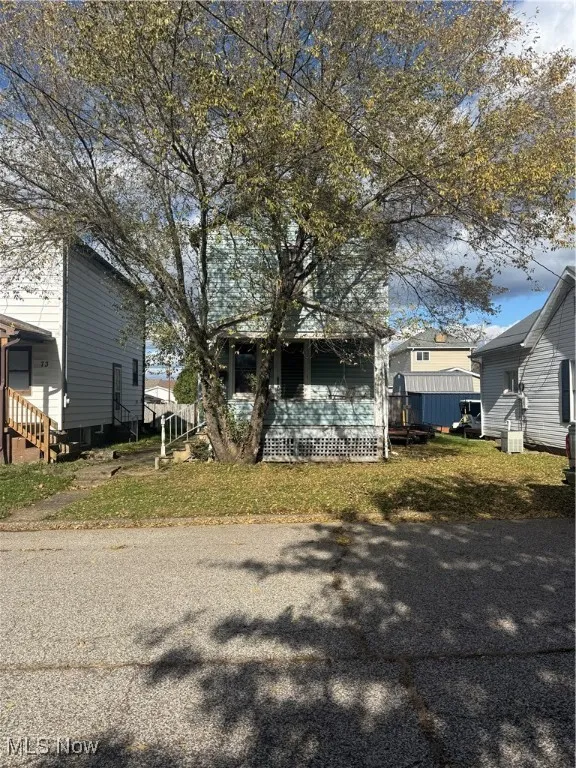 View of front of property featuring a front yard and a wooden deck