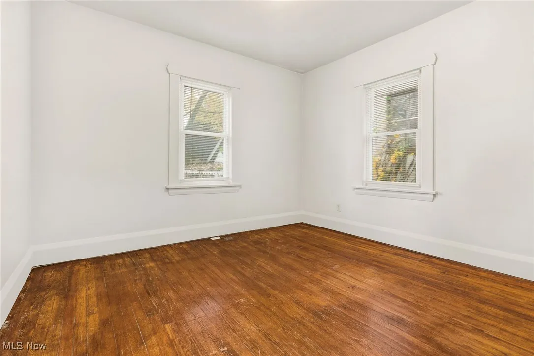 Spare room featuring plenty of natural light and dark wood finished floors