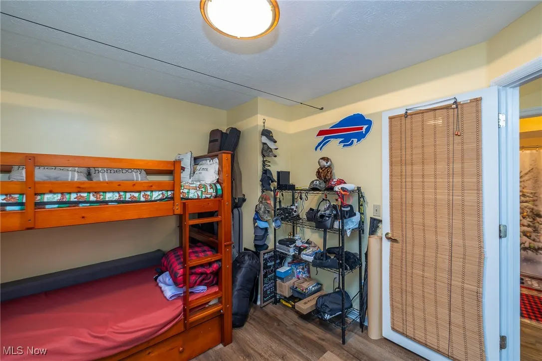 Bedroom with dark wood-style floors and a textured ceiling