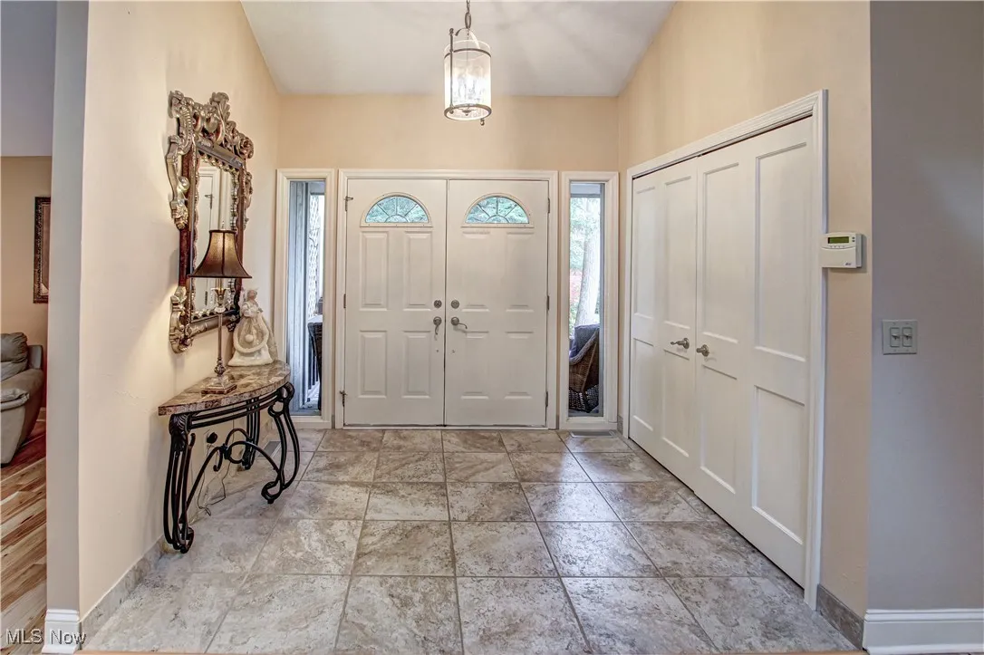 Front entry foyer with coat closet and Travertine tile.
