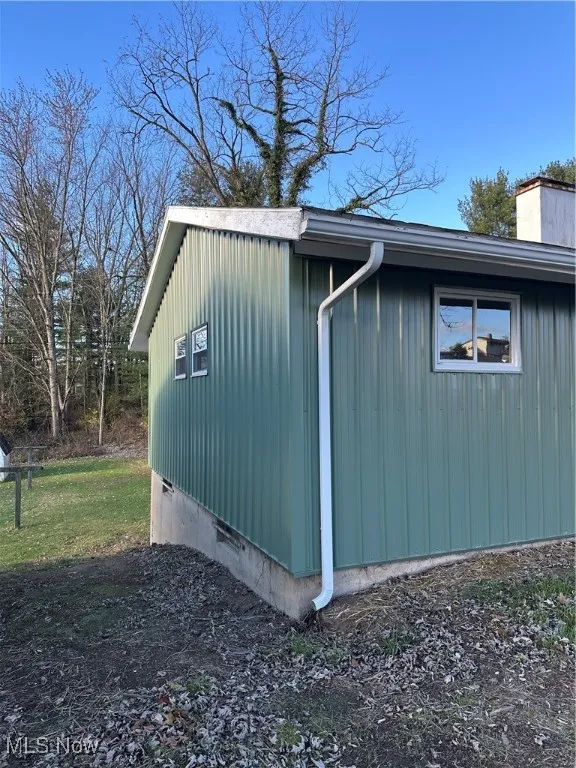 View of side of home featuring metal siding, and full unfinished basement