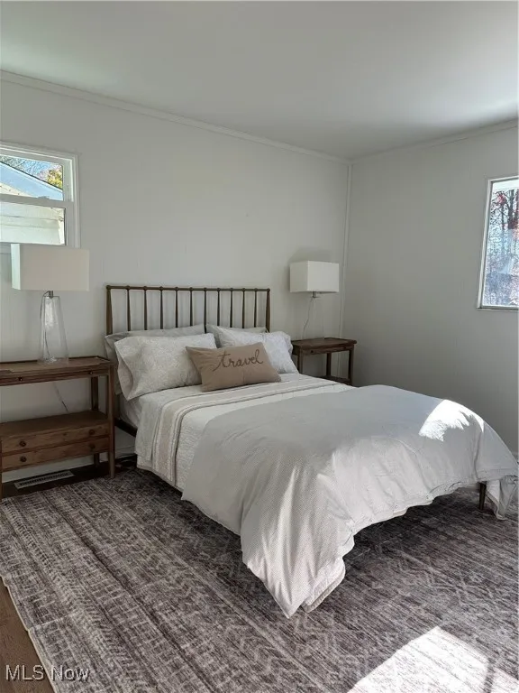 Bedroom #2 featuring multiple windows, crown molding, and LVF floors