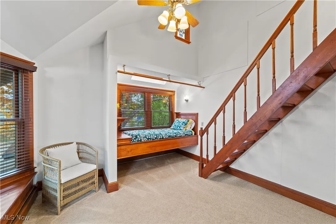 Bedroom with light carpet, vaulted ceiling, and a ceiling fan