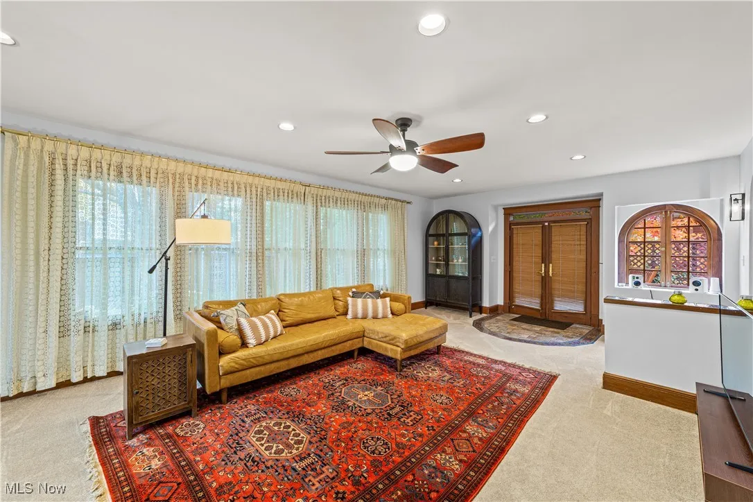 Living area with healthy amount of natural light, recessed lighting, a ceiling fan, and light colored carpet