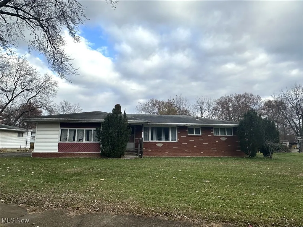 Ranch-style house with a front lawn, brick siding, and entry steps