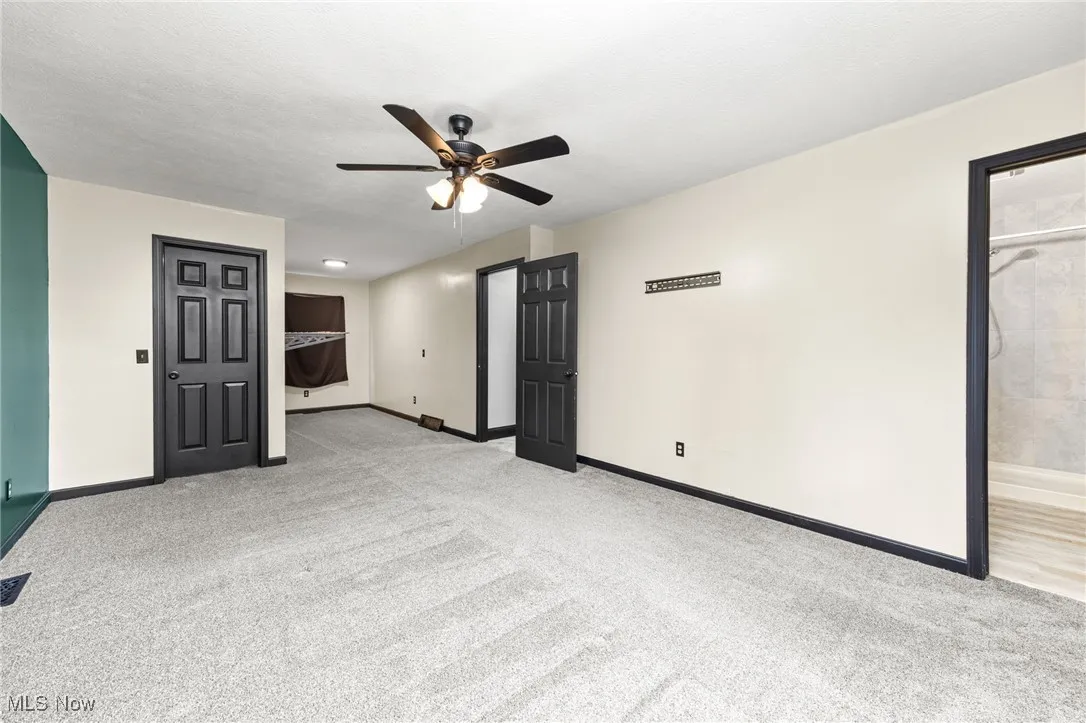 Unfurnished room with light colored carpet and ceiling fan