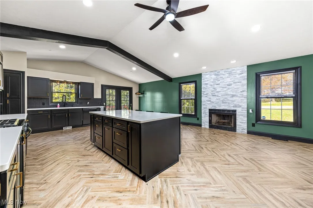 Kitchen with tasteful backsplash, a fireplace, gas stove, healthy amount of natural light, and recessed lighting