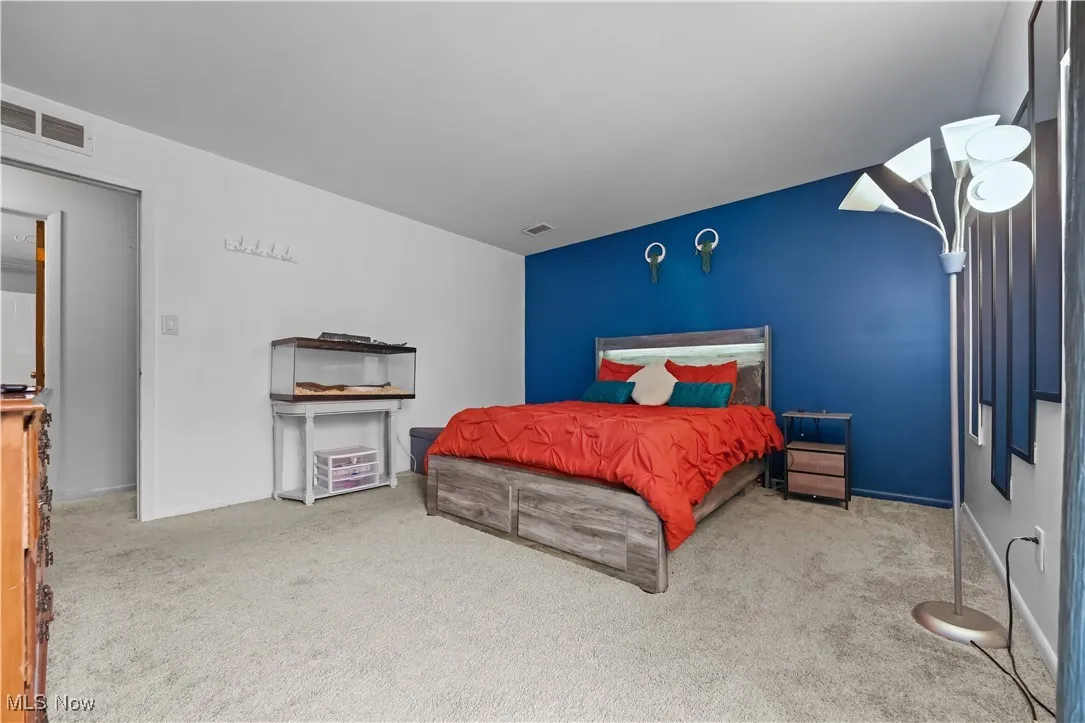 Bedroom featuring carpet and baseboards