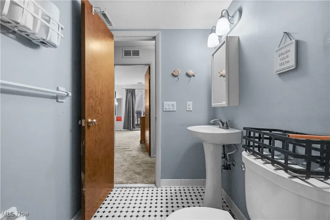 Bathroom with light tile patterned floors and light carpet