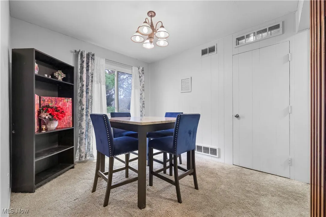 Dining room with a chandelier and light carpet