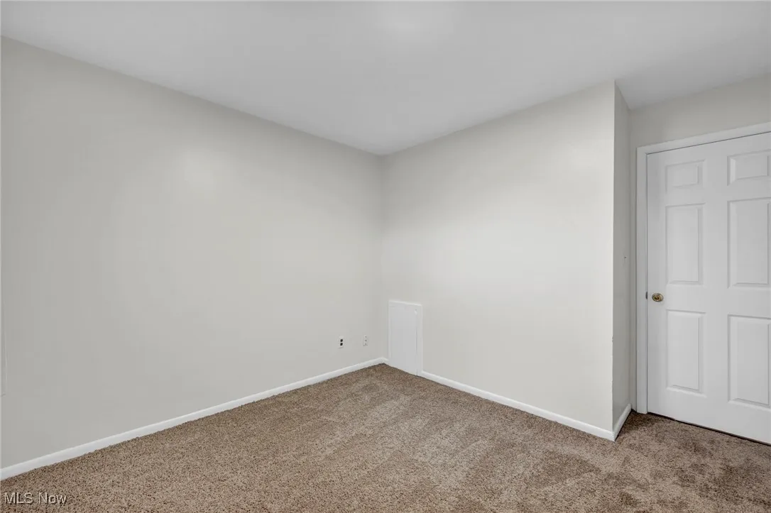 Spare room featuring baseboards and carpet floors