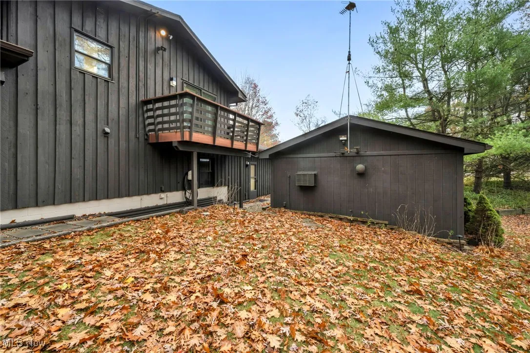 Back of house featuring a wooden deck and an AC wall unit