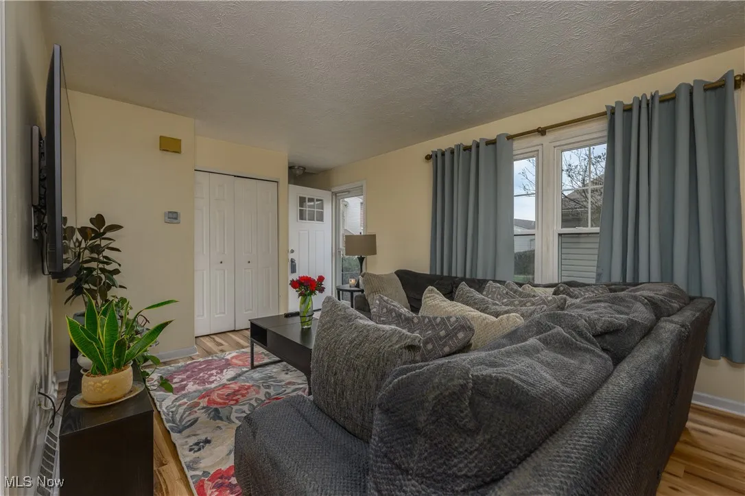 Living area featuring a textured ceiling and light wood-style floors