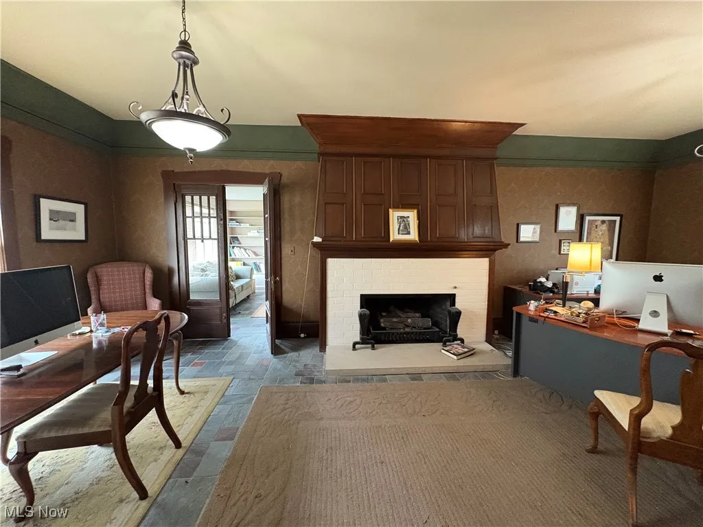 Office with a brick fireplace and stone finish flooring