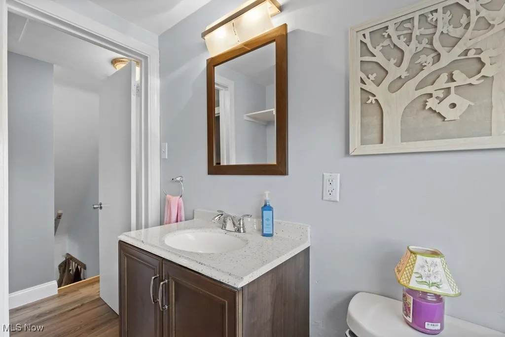 Half bathroom with vanity and wood finished floors