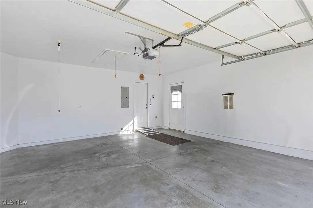 Garage featuring electric panel and a garage door opener