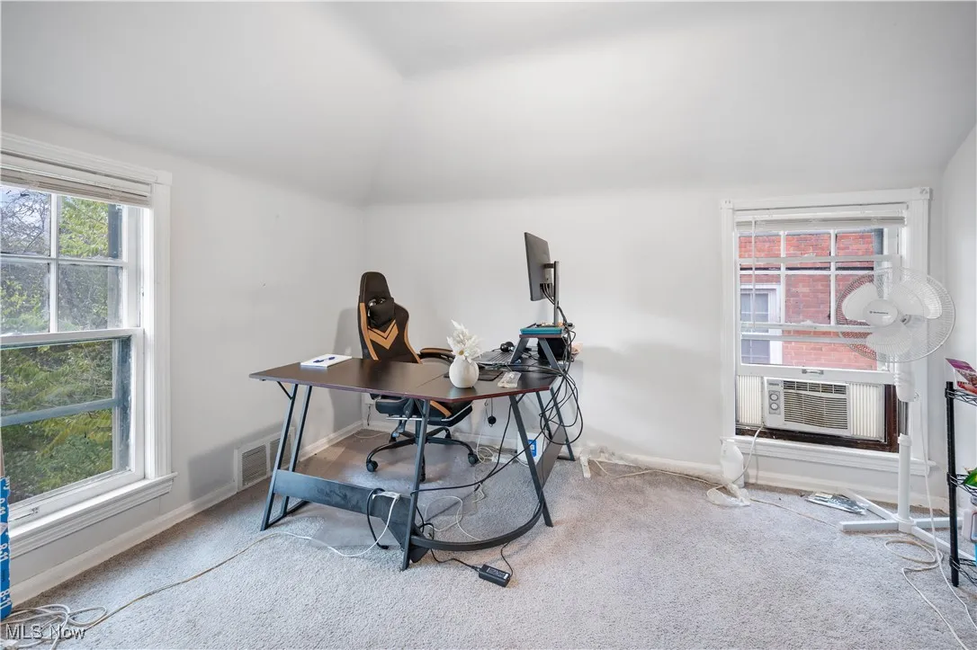 Office area with healthy amount of natural light, carpet floors, and lofted ceiling