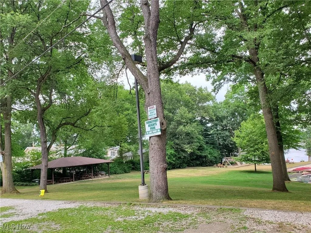 View of property's community with a yard and view of wooded area