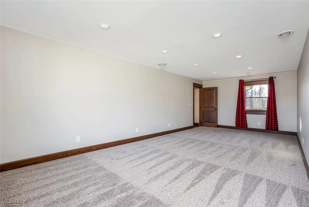 Carpeted spare room featuring recessed lighting