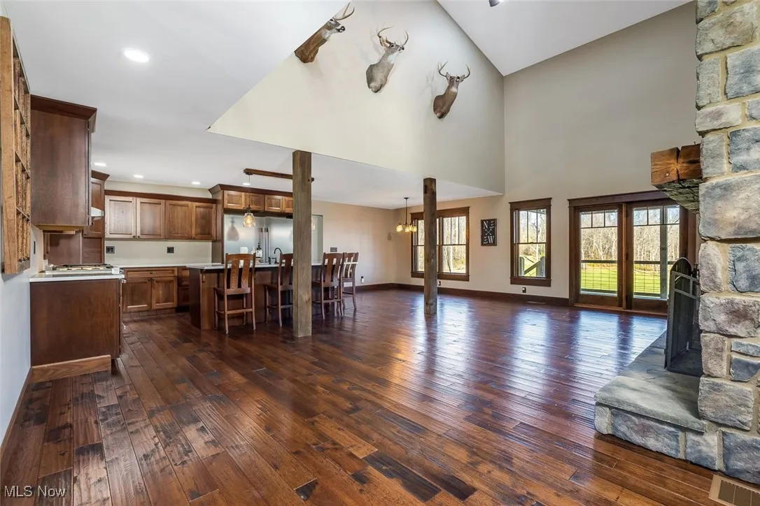 Living room with dark wood-style flooring, recessed lighting, a chandelier, and a fireplace