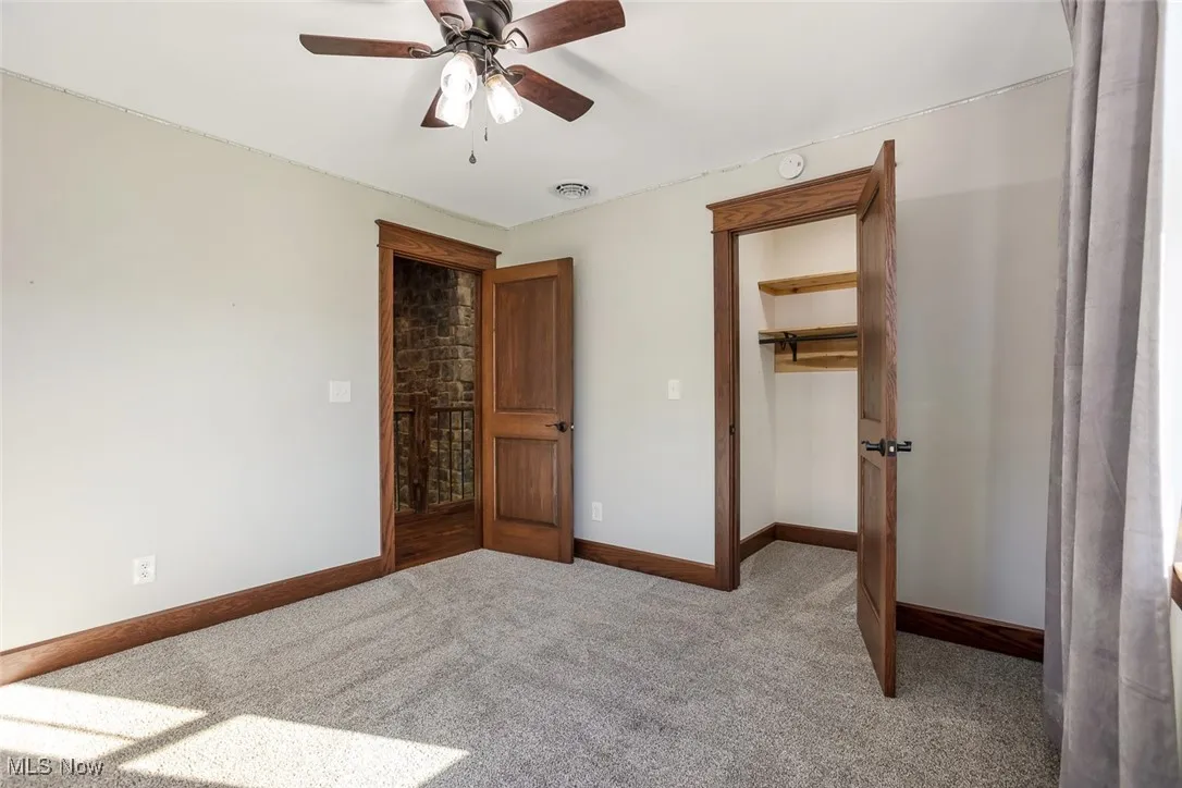 Unfurnished bedroom with carpet floors and a ceiling fan