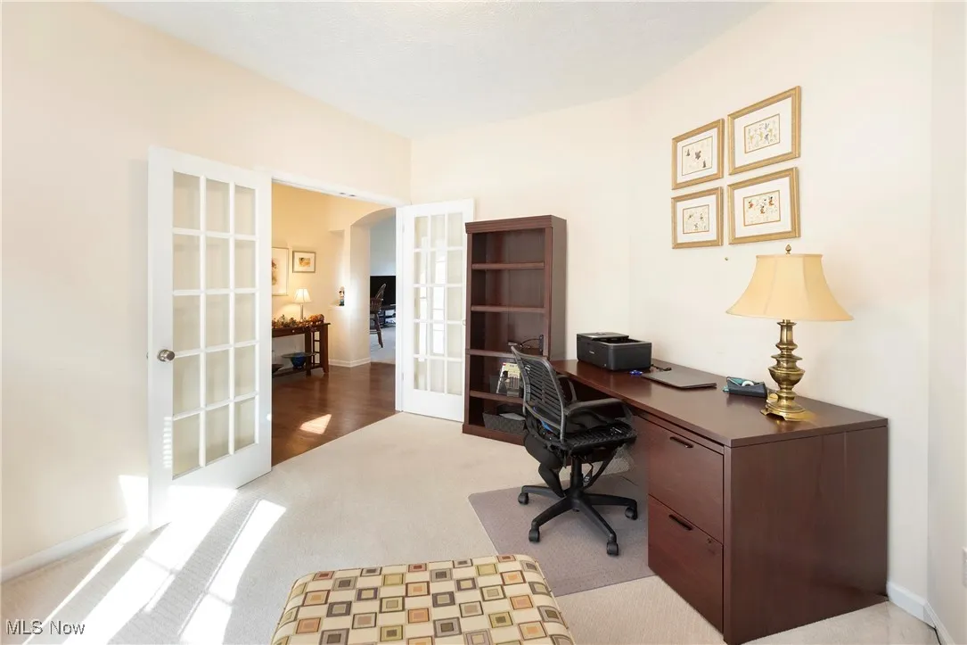 Home office featuring french doors and light carpet