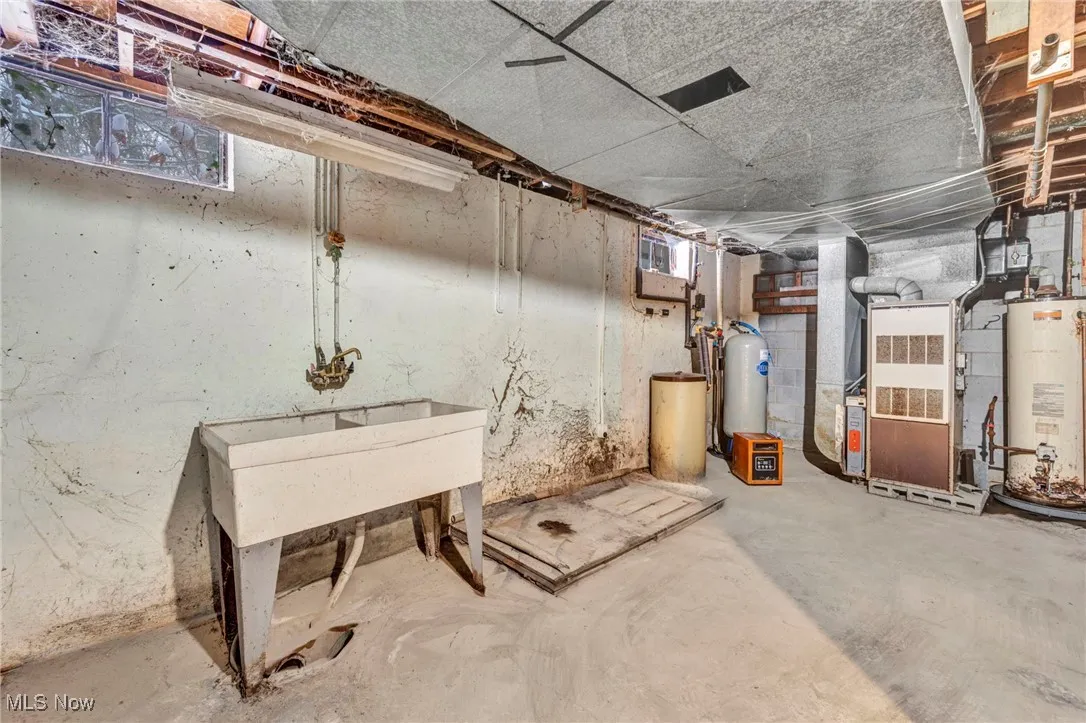 Unfinished basement with water heater, a water softener system, and heating unit