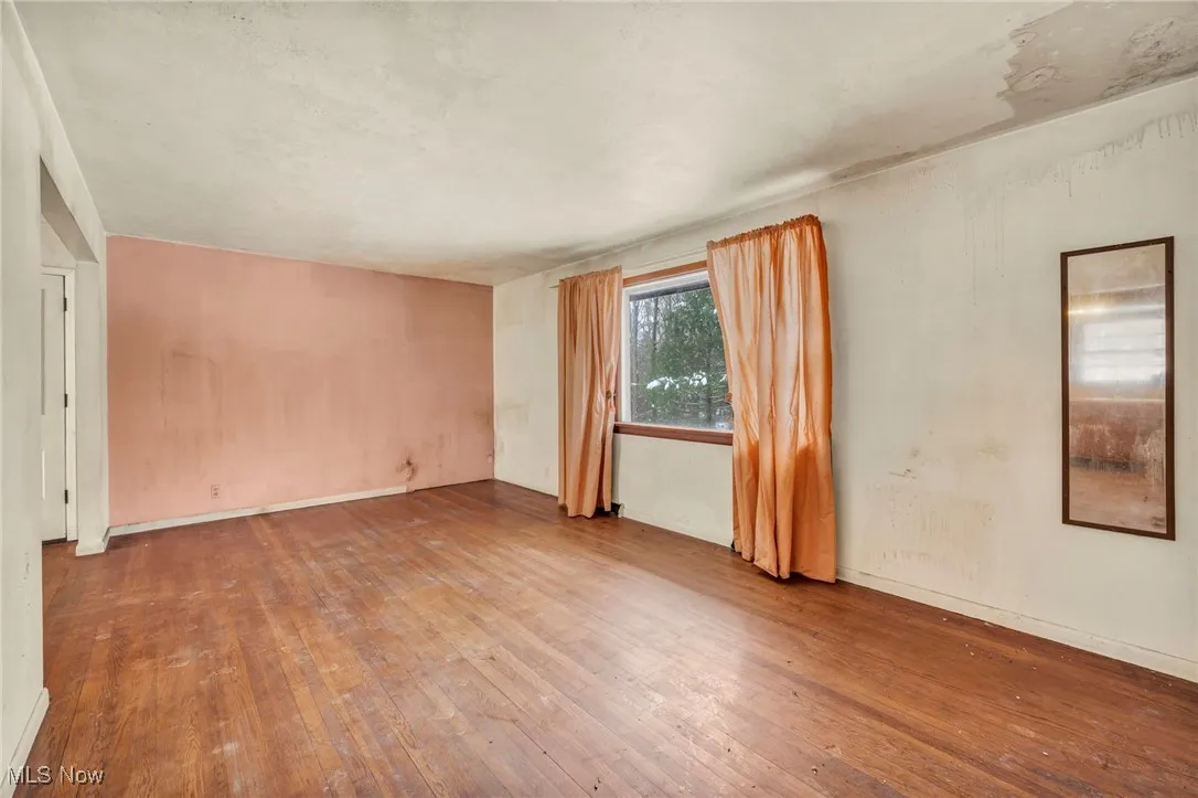 Unfurnished room with hardwood / wood-style flooring and baseboards