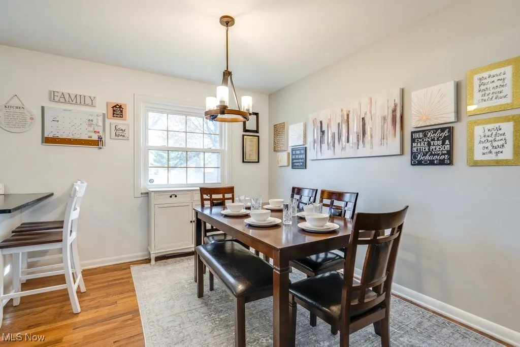 Dining space with light wood-style floors and a chandelier