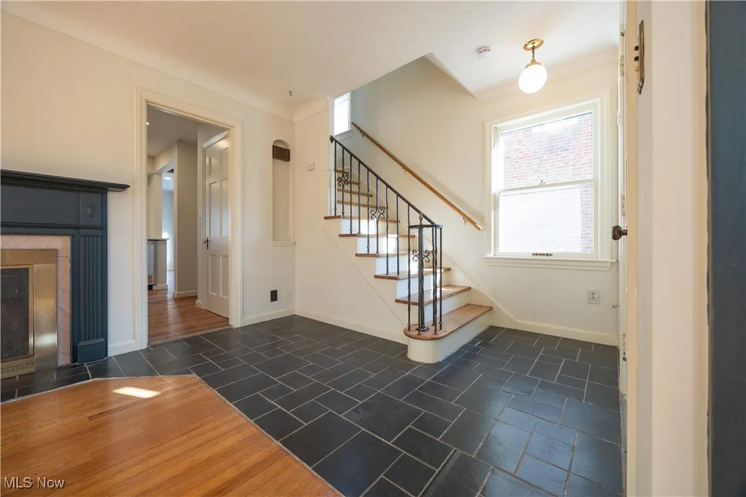 Staircase featuring baseboards and a fireplace with flush hearth