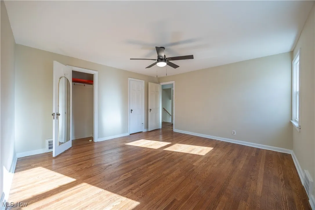 Unfurnished bedroom with wood finished floors and a ceiling fan