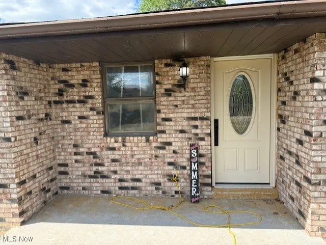 Property entrance featuring brick siding