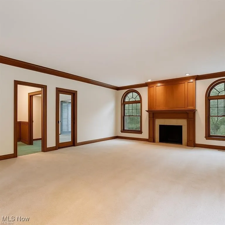 Great room  featuring ornamental molding a large fireplace, and recessed lighting