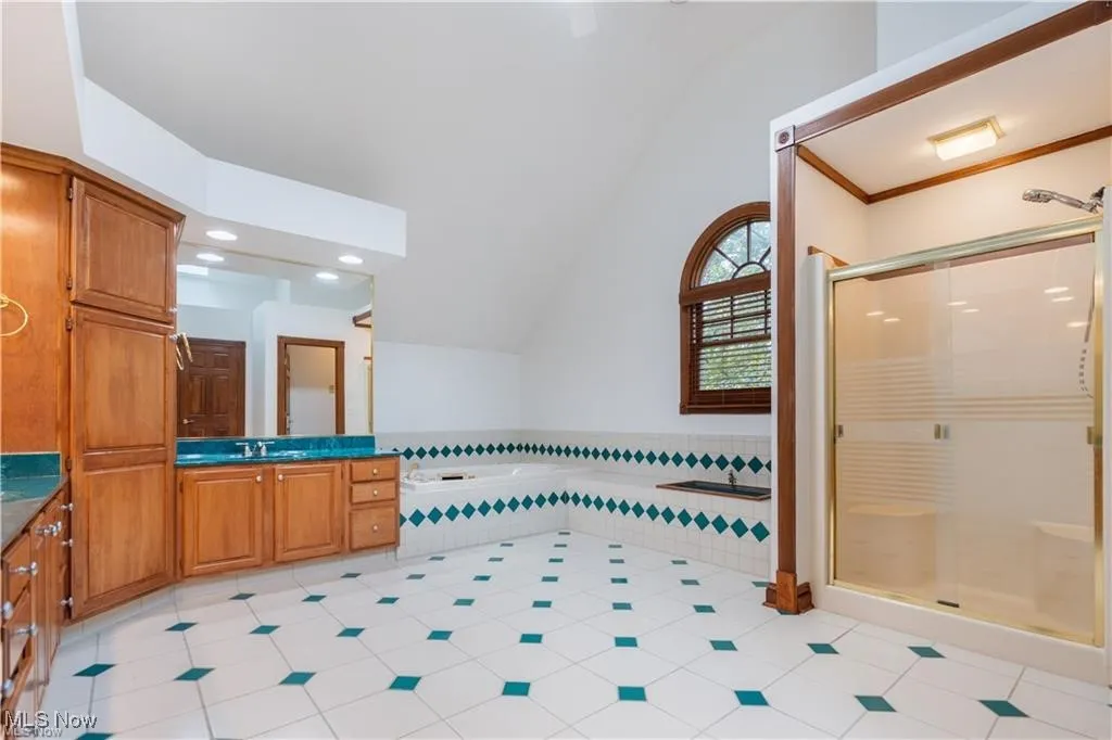 This additional angle highlights the spacious primary bath, featuring dual vanities, a relaxing tub, and a convenient walk-in shower