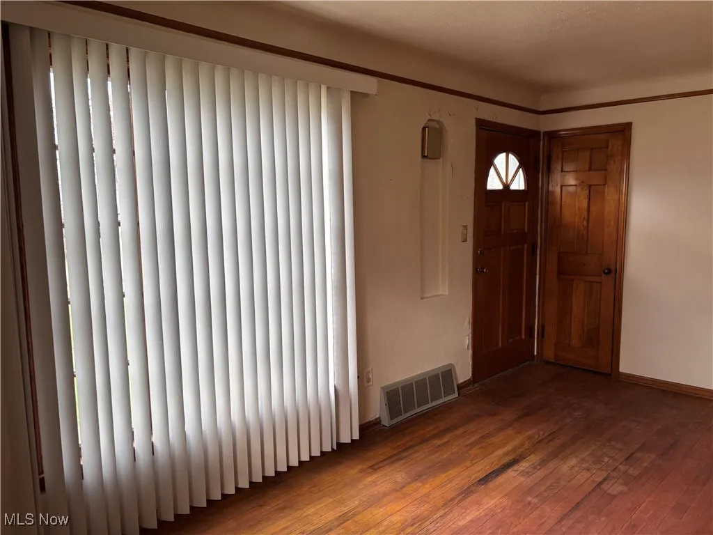Entrance foyer featuring dark wood-type flooring and baseboards