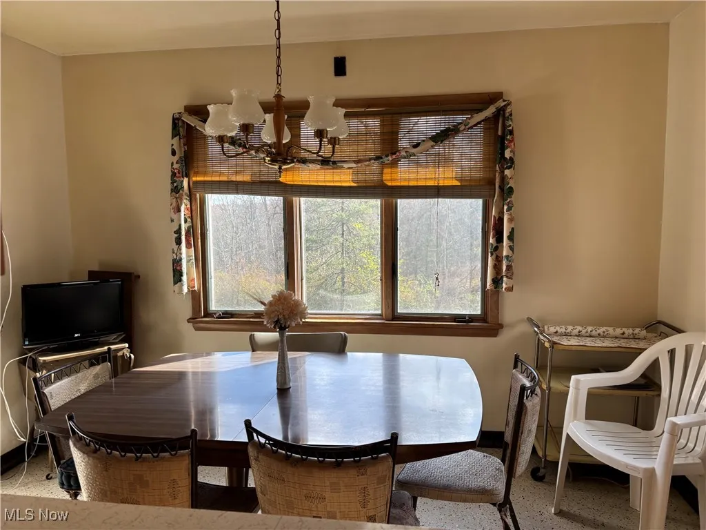 Dining area featuring a chandelier and baseboards